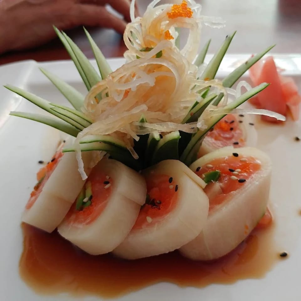 Thai Thai Cocoa Village's sushi rolls with salmon, daikon, cucumber, and roe, drizzled with sauce.